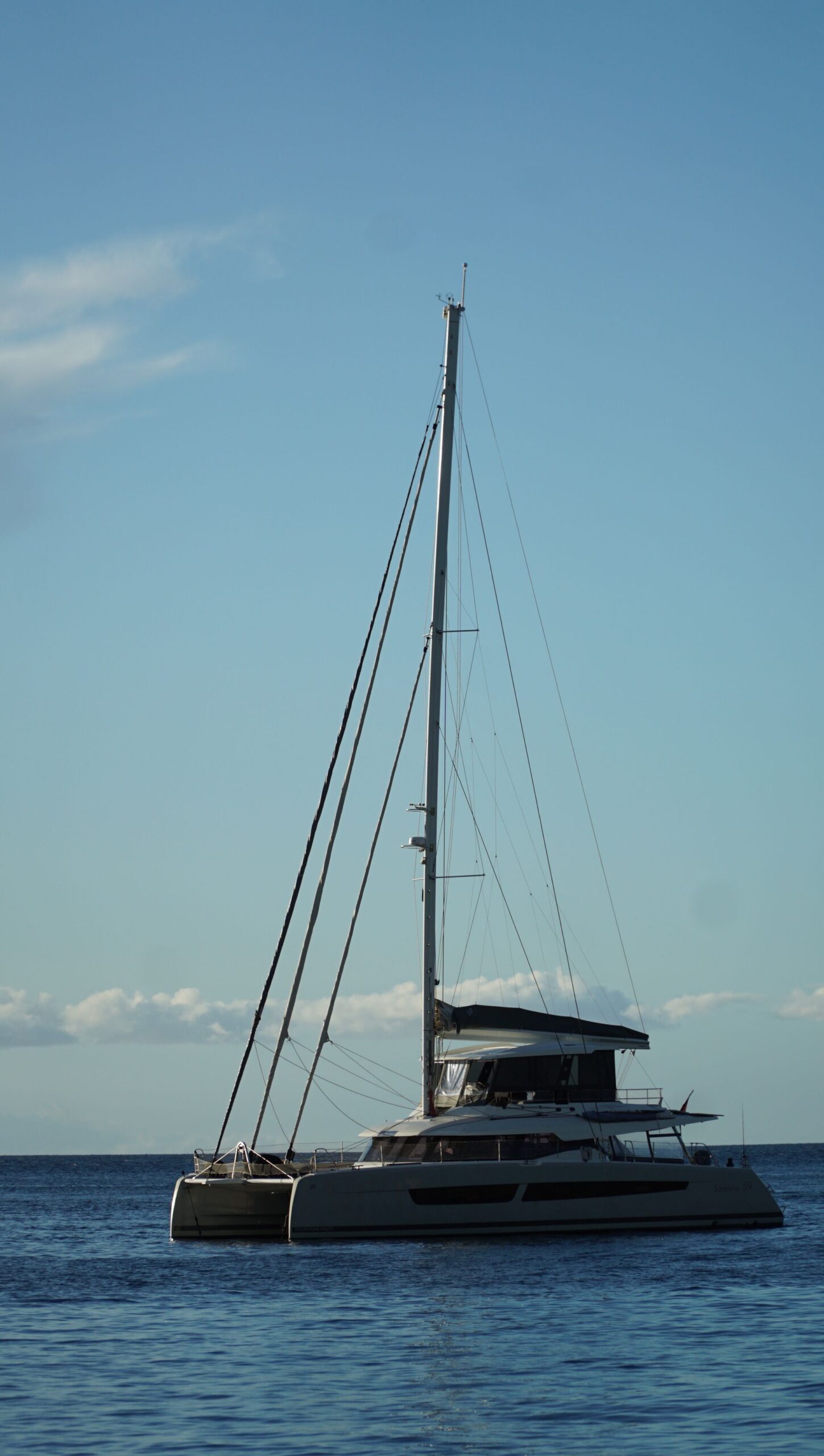 Catamarã ancorado com o mastro recortado contra o céu