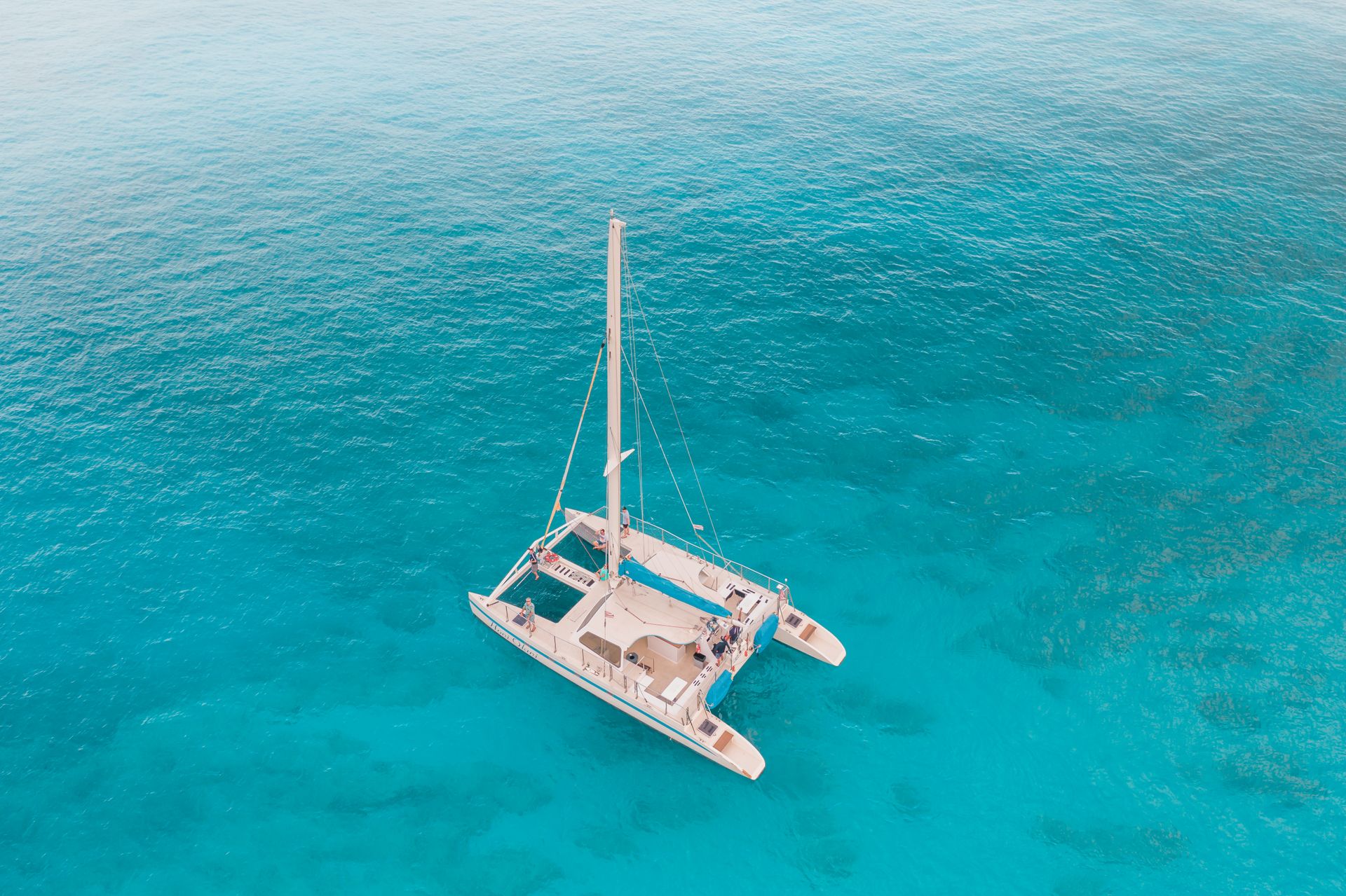 Vista aérea de um catamarã navegando em águas turquesa